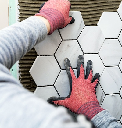 Man installing white marble backsplash in Pompano Beach