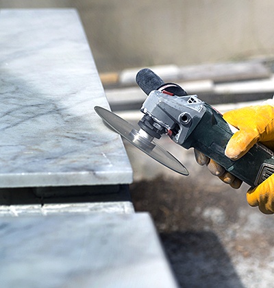 Man repairing and polishing marble with angle grinder