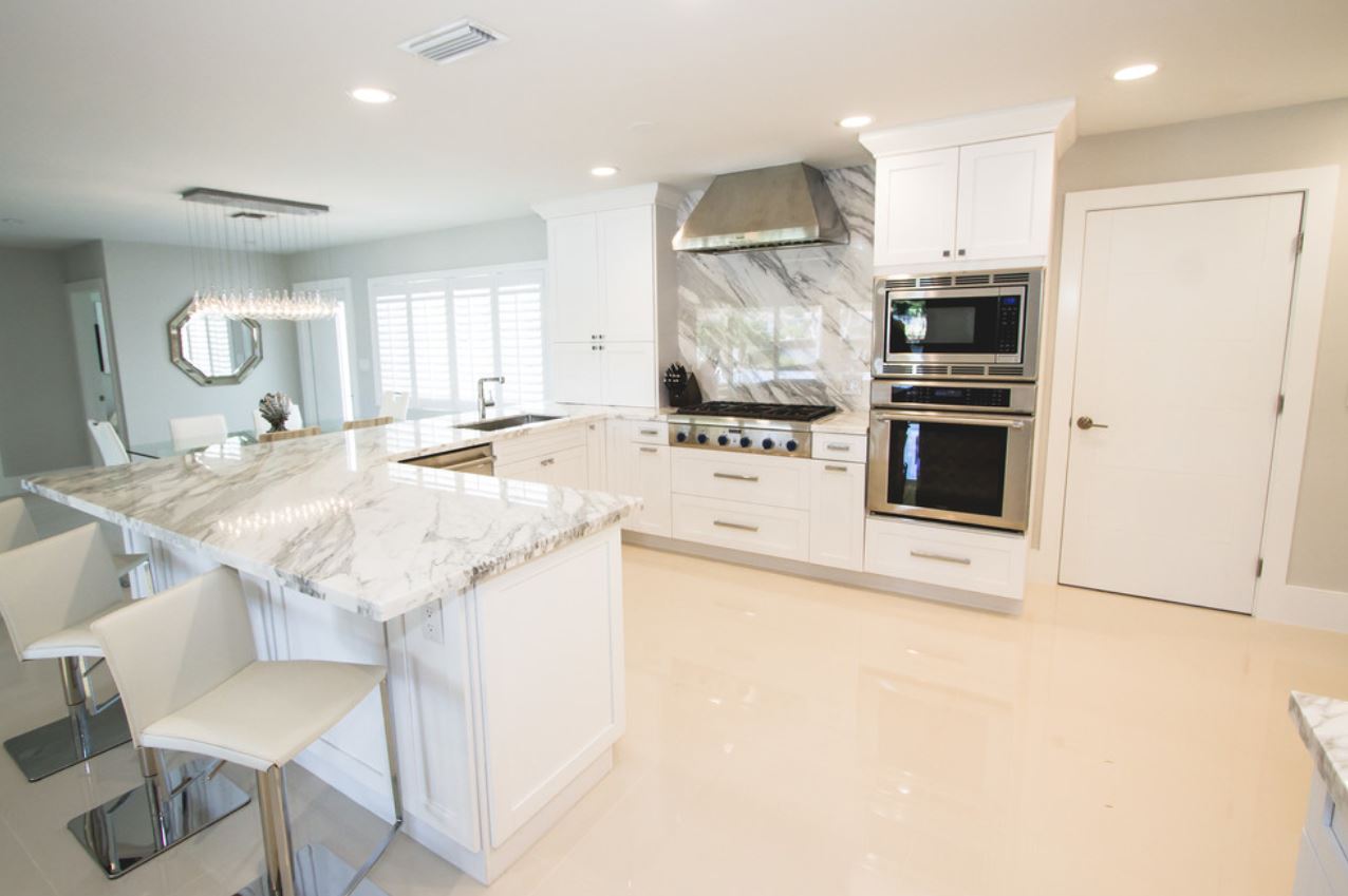 white marble countertops in kitchen connecting to oven backsplash